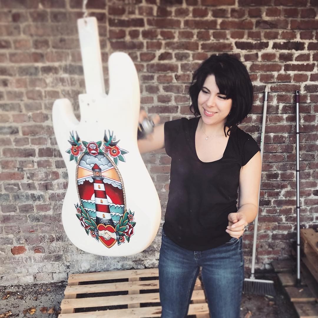 Julie dans son atelier, devant un corps de basse peint d'un phare old school